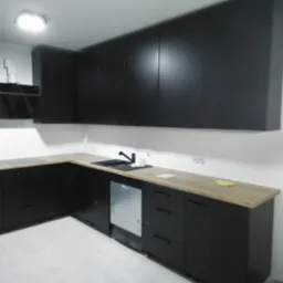 Nowoczesna kuchnia z czarnymi szafkami i blatem z jasnego drewna, widoczna zlew i bateria, minimalistyczny design, oświetlenie sufitowe.