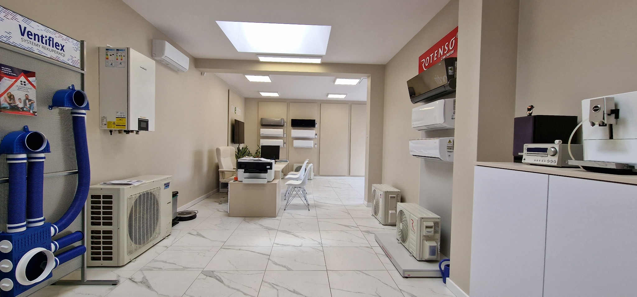 Wnętrze salonu z ekspozycją systemów wentylacji mechanicznej z odzyskiem ciepła oraz klimatyzatorów, widoczne elementy instalacji rekuperacji Ventiflex, klimatyzatory Rotenso, ekspres do kawy Jura...
