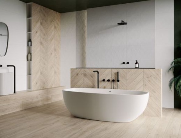 Nowoczesna łazienka w Ostródzie z wolnostojącą białą wanną, armaturą w kolorze czarnym i drewnopodobnymi płytkami ułożonymi w jodełkę na ścianie.