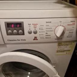 Pralka Bosch Classixx for Kids z otwartymi drzwiczkami, widoczny panel sterowania z ustawionym programem i naklejką informującą o niskim zużyciu energii.