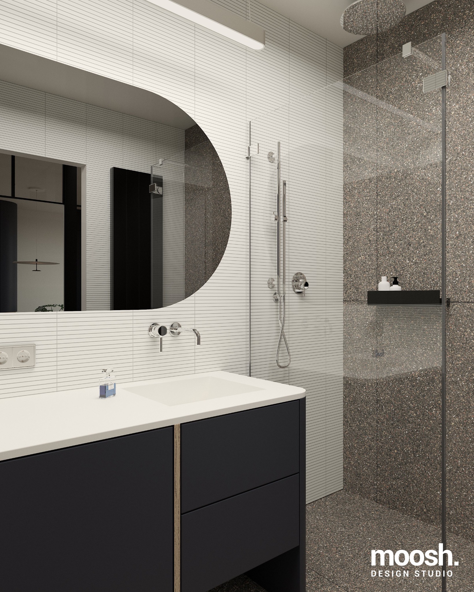 Nowoczesna łazienka z umywalką nablatową na czarnej szafce, okrągłym lustrem, baterią ścienną i kabiną prysznicową wykończoną płytkami imitującymi lastryko.