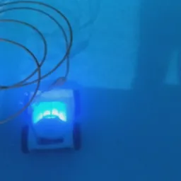 Automatyczny odkurzacz do czyszczenia dna basenu, zanurzony w wodzie, z widocznym kablem zasilającym i niebieskim podświetleniem.