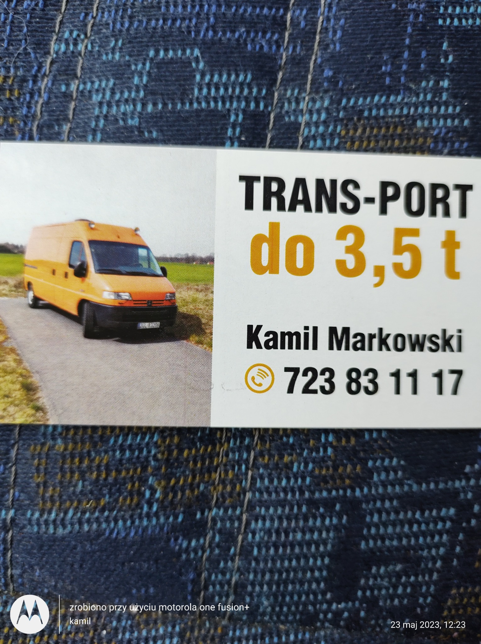 Zdjęcie wizytówki firmy transportowej z pomarańczowym busem do 3,5 tony na tle drogi i pola.