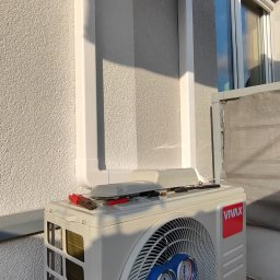 ClimaKor Bartłomiej Kordyk - Zewnętrzna jednostka klimatyzacji marki Vivax z podłączonymi manometrami serwisowymi, umieszczona na balkonie, z widocznymi rurami odprowadzającymi skropliny i narzędziami na obudowie.