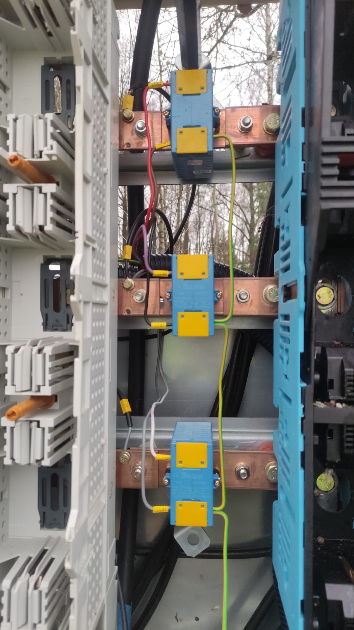 Szyna wyrównawcza potencjałów z podłączonymi przewodami w rozdzielnicy elektrycznej, widoczne elementy mocujące i oznaczenia przewodów.