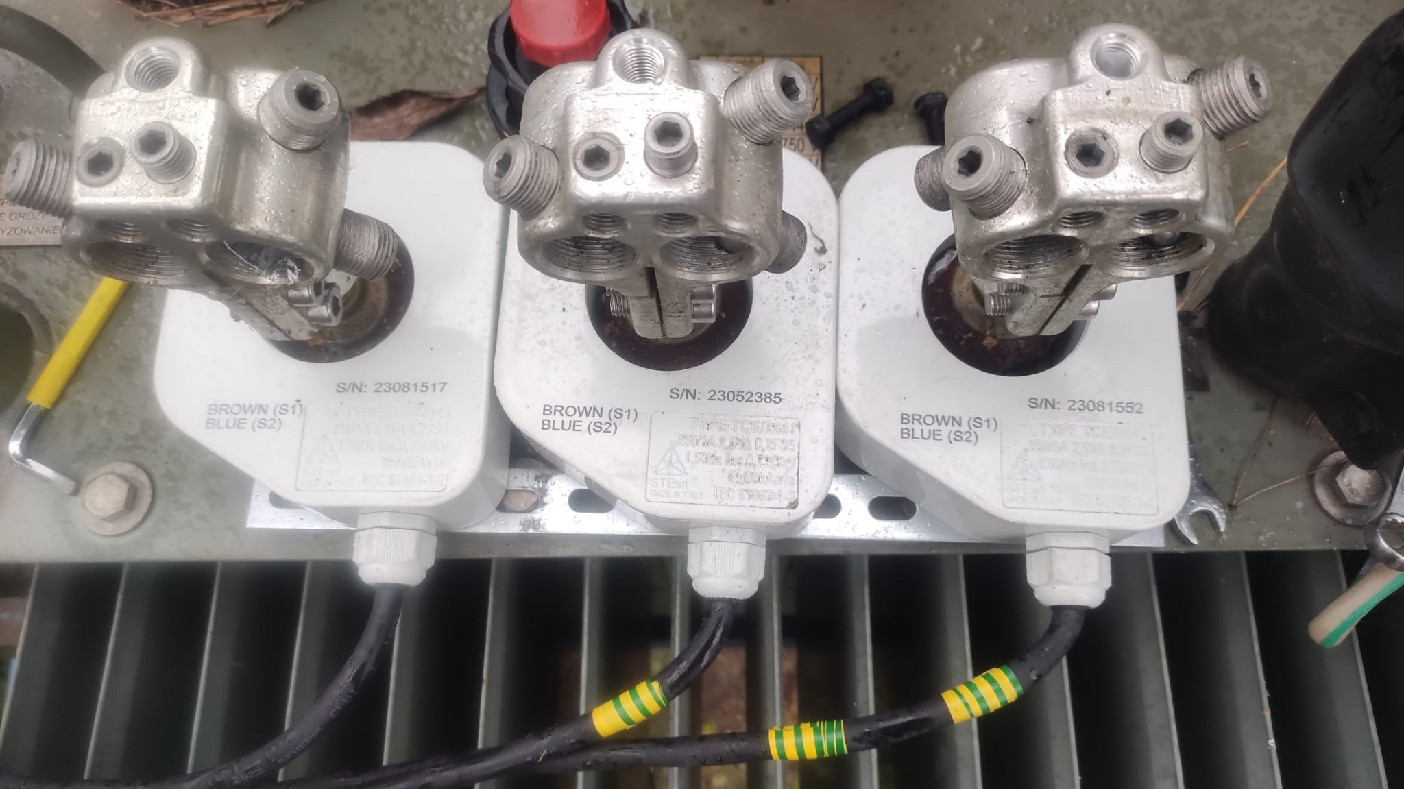 Szczegółowe ujęcie trzech przekładników prądowych z oznaczeniami BROWN (S1) BLUE (S2) i numerami seryjnymi, zamontowanych w instalacji elektrycznej w Kłobucku.