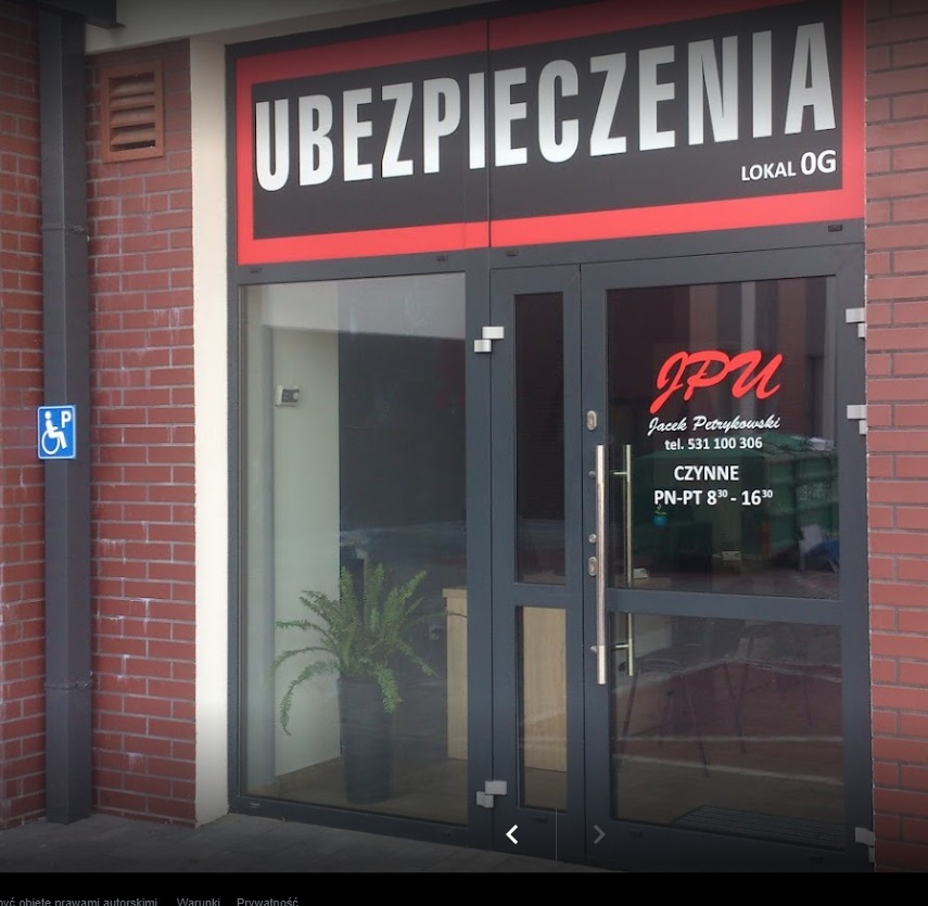 Wejście do biura z napisem 'Ubezpieczenia', lokal OG, z widoczną informacją o godzinach otwarcia i logo firmy JPU Jacek Petrykowski. Obok wejścia znak dla osób niepełnosprawnych.