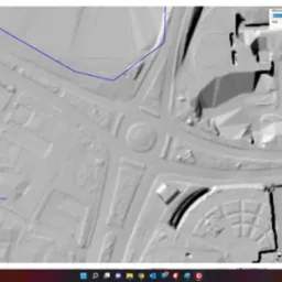 Aplikacja mapowa prezentująca cieniowany model terenu z zaznaczonymi drogami, budynkami i rondem, w oknie programu z widocznymi narzędziami do edycji warstw i opisów. Mapa zawiera informacje...