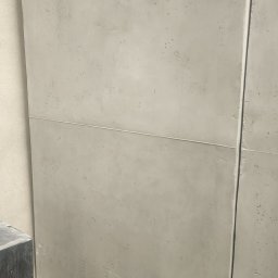 Morozov BUD - Szare, betonowe płyty ścienne z widoczną fugą, ułożone w poziomie. Delikatna tekstura betonu z drobnymi porami. Minimalistyczny design, nowoczesne wykończenie wnętrza.