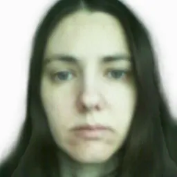 Portret kobiety z długimi, ciemnymi włosami na rozmytym, białym tle.