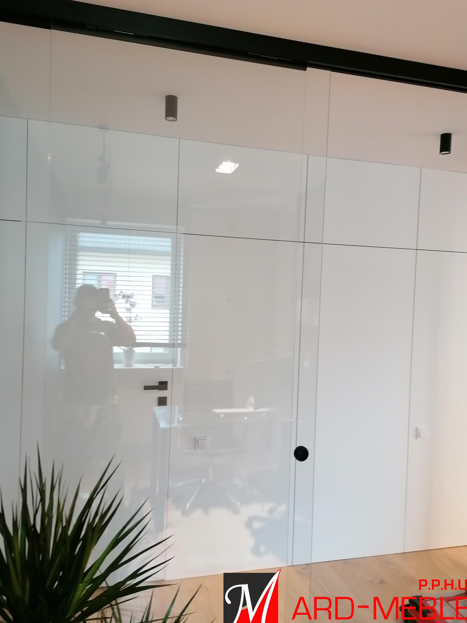 Lakierowana w połysku obudowa ścian z ukrytymi drzwiami.