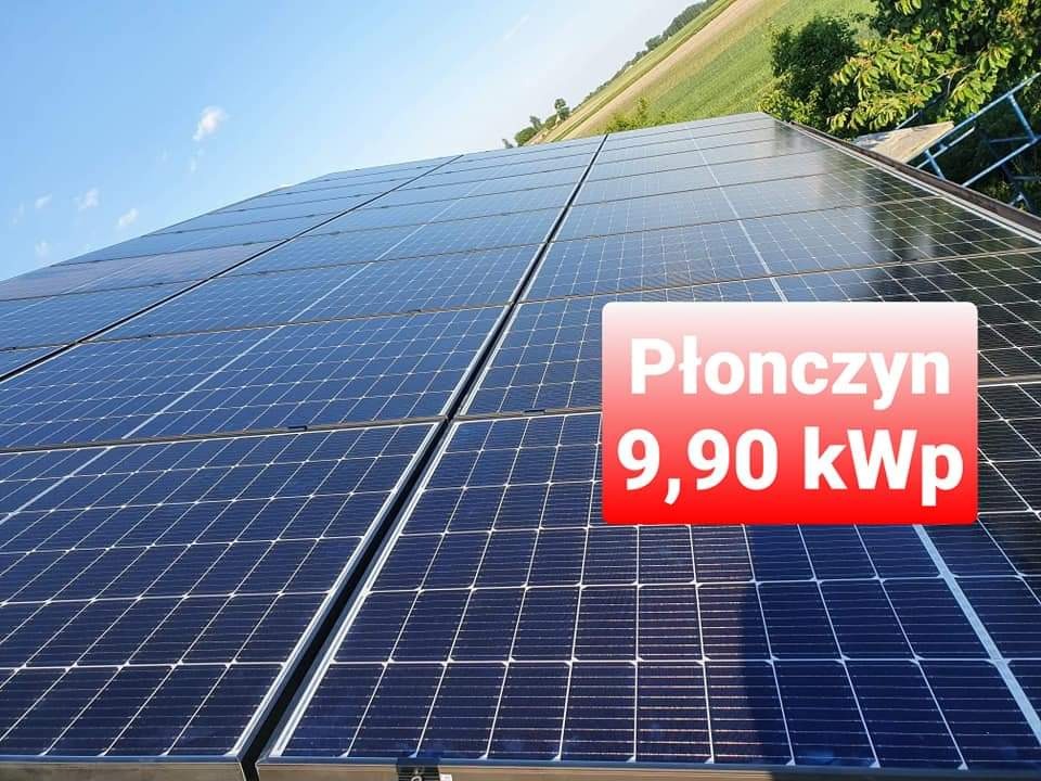 Instalacja paneli słonecznych na dachu z widocznym polem uprawnym w tle, z naniesionym tekstem 'Płończyn 9,90 kWp'.