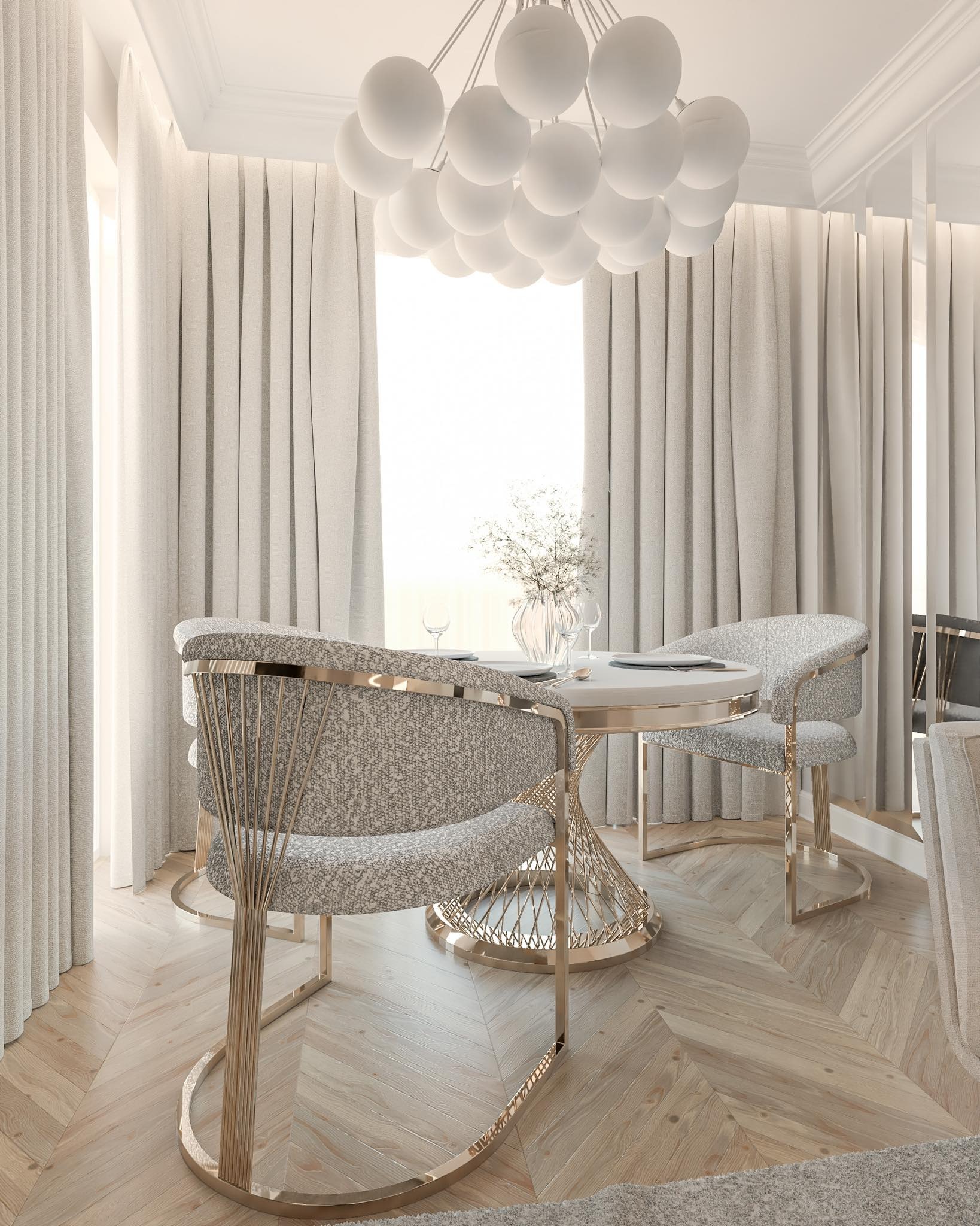 Elegancka jadalnia w jasnych barwach z okrągłym stołem, krzesłami z metalowymi elementami i designerską lampą wiszącą, na tle okna z delikatnymi zasłonami.