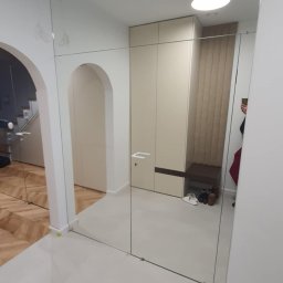 Perfekt Glass - Szklana ściana działowa w przedpokoju, z widocznym wejściem łukowym i szafą wnękową. Minimalistyczny design, jasne kolory, odbicie w szkle.