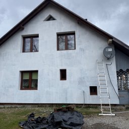 PEDRO-POLAKO Lucas VLASÁK - Ściana domu po nałożeniu pierwszej warstwy tynku, widoczna drabina oparta o ścianę, przygotowania do dalszych prac elewacyjnych.