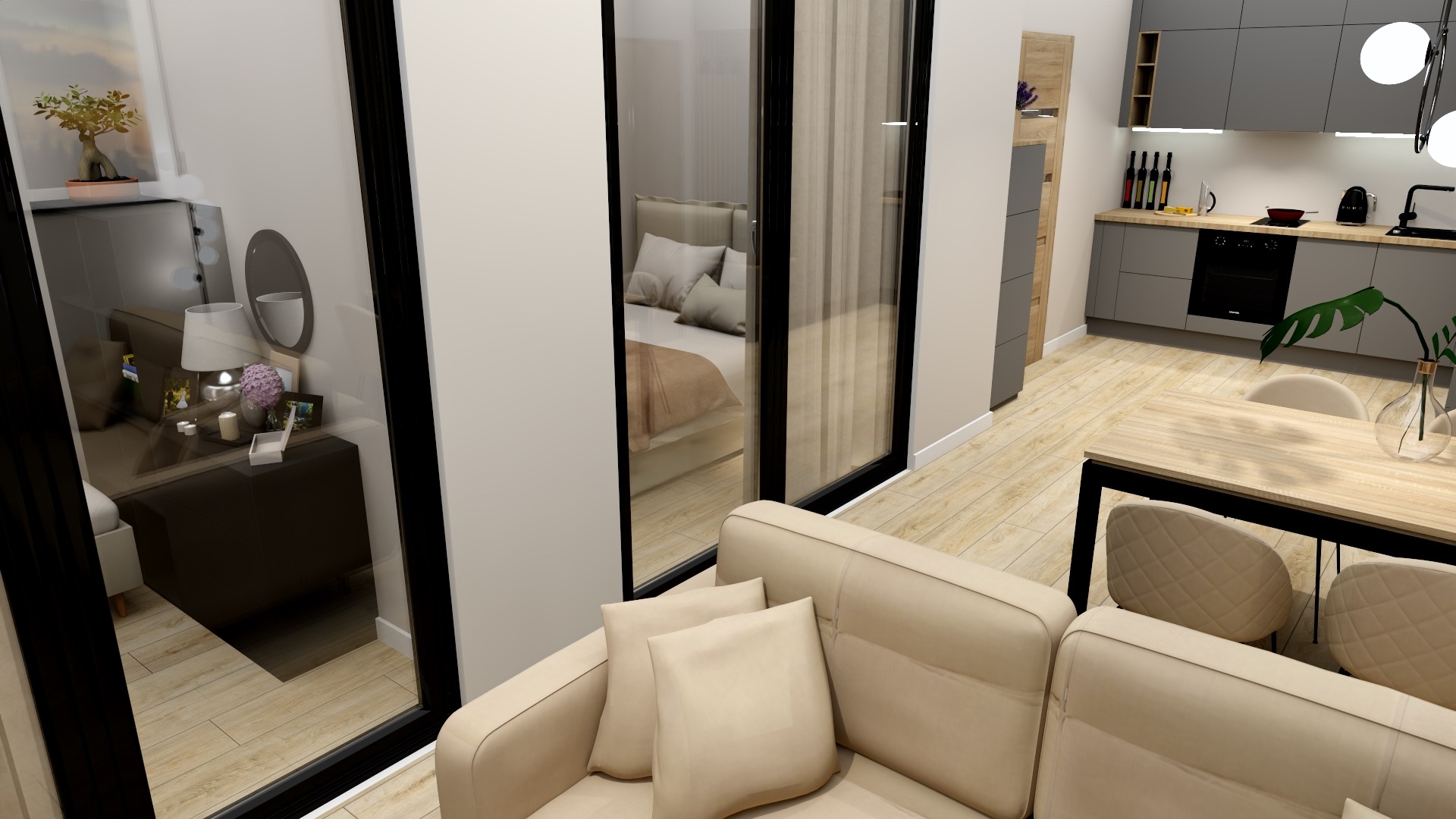 Wnętrze mieszkania z widokiem na sypialnię przez szklane drzwi, beżowa sofa z poduszkami na pierwszym planie, w tle kuchnia z szarymi szafkami i drewnianym blatem.