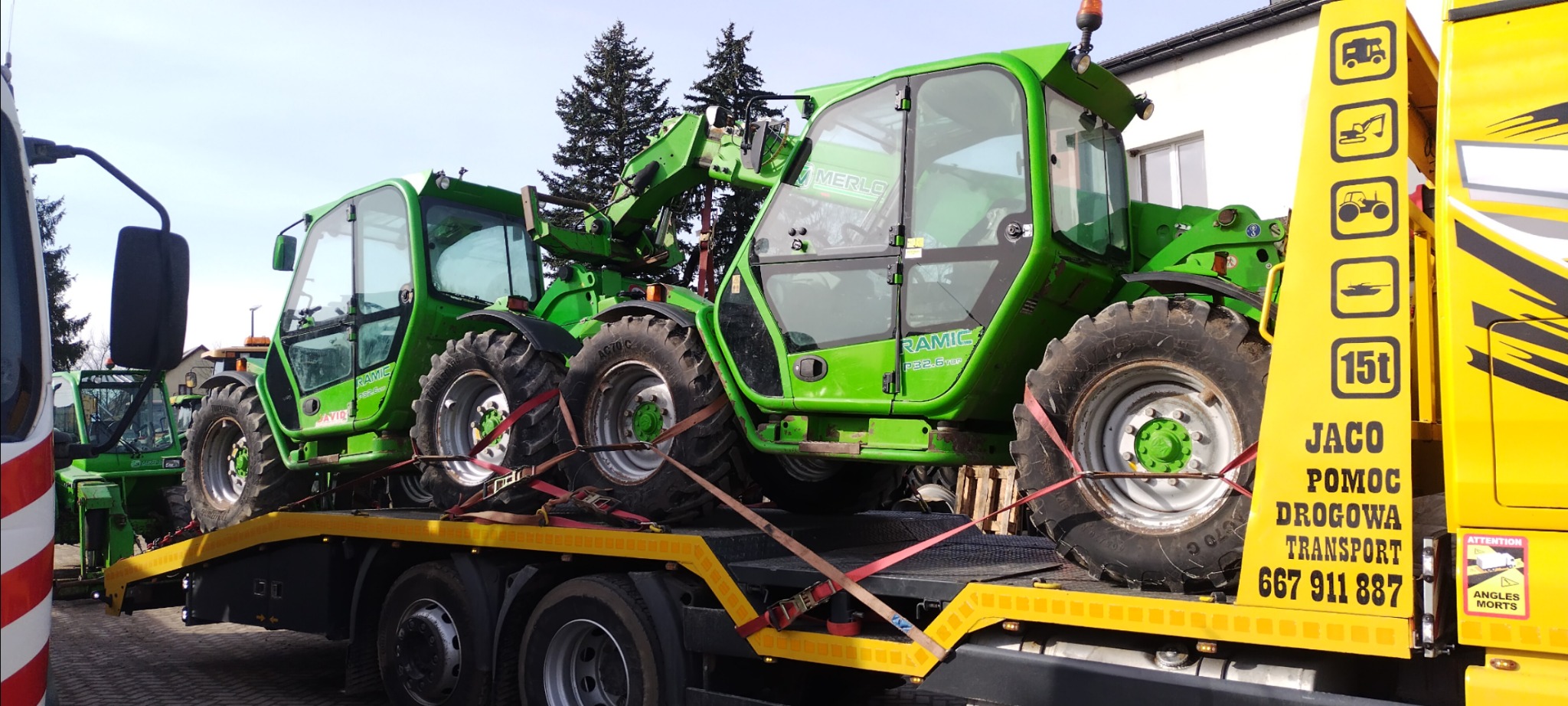 Dwa zielone manipulatory teleskopowe Merlo Ramic zabezpieczone pasami na platformie lawety pomocy drogowej Jaco z żółtym oznakowaniem i numerem telefonu.