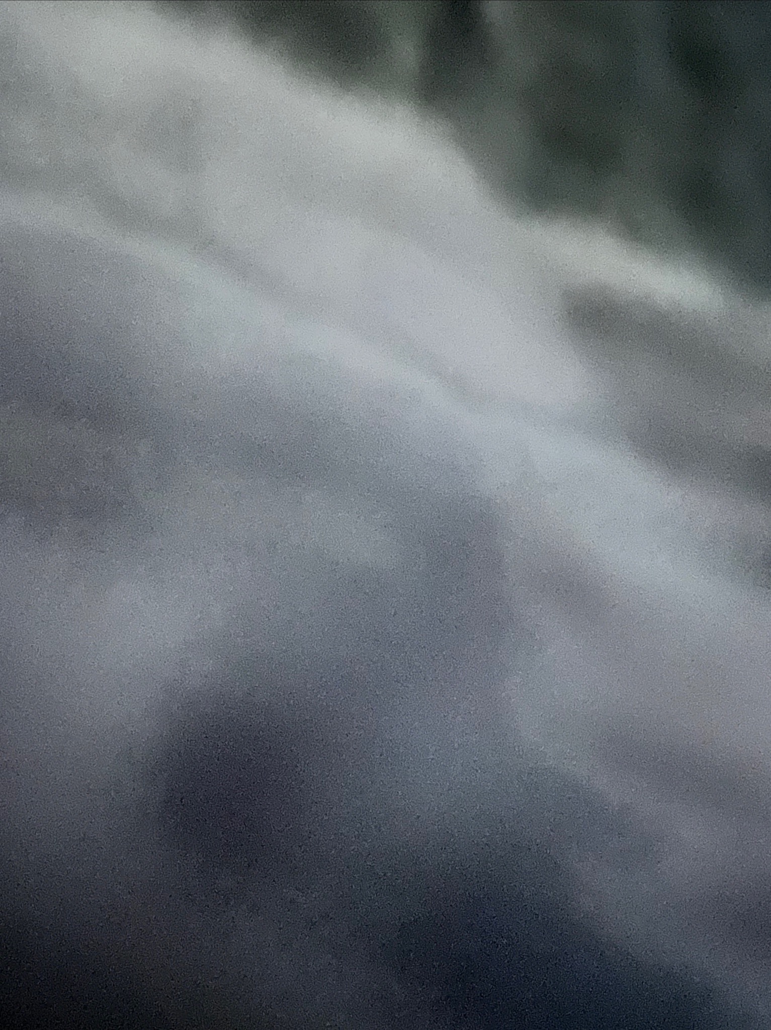 Abstrakcyjna fotografia z rozmytymi warstwami szarości i bieli, przypominająca chmury lub dym.