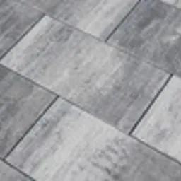 Szare, prostokątne płyty chodnikowe ułożone w regularny wzór, widoczne z góry, z delikatną teksturą i subtelnymi przebarwieniami.