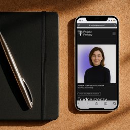 Recreate Sp. z o.o. - Strona internetowa Projekt Prawny na smartfonie we Wrocławiu, leżącym obok czarnego notatnika i srebrnego długopisu na teksturowanym tle. Minimalistyczny design.