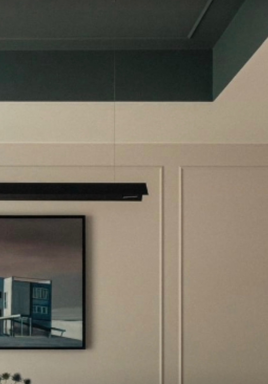 Nowoczesne wnętrze: ciemnozielony sufit z oświetleniem szynowym, kremowe ściany z dekoracyjnymi listwami, obraz w czarnej ramie przedstawiający budynek.