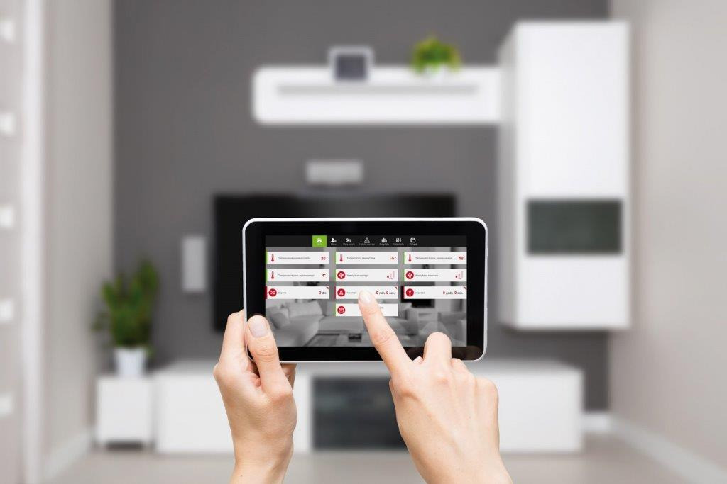 Tablet z aplikacją do sterowania rekuperacją w nowoczesnym salonie, widok z perspektywy użytkownika podczas regulacji ustawień.
