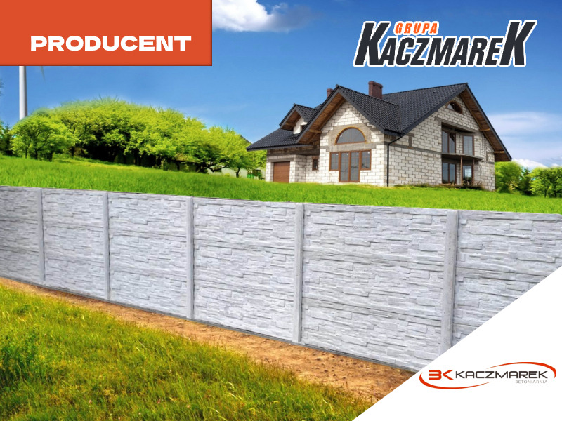 Długi, szary mur z prefabrykatów o teksturze kamienia, oddzielający posesję z domem od łąki, na górze logo producenta.