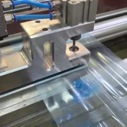 Automatyczna linia produkcyjna formująca foliowe torby zgrzewane na gorąco, z widocznym mechanizmem zgrzewającym i rolką folii.