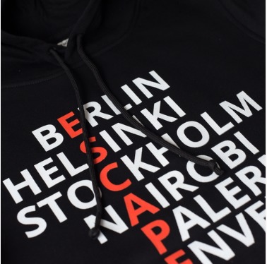 Czarna bluza z kapturem, na której widnieje biały napis z nazwami miast: Berlin, Helsinki, Sztokholm, Nairobi, Palermo, Denver, z wyróżnionym czerwonym napisem 'ESCAPE' krzyżującym się z nazwami...