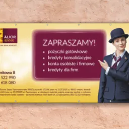 Banner reklamowy Alior Banku z wizerunkiem kobiety w garniturze i kapeluszu, oferujący pożyczki gotówkowe, kredyty konsolidacyjne, konta osobiste i firmowe oraz kredyty dla firm, zawieszony...