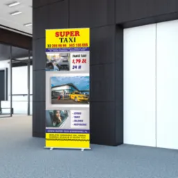 Roll-up reklamowy z ofertą usług taksówkarskich firmy Super Taxi, umieszczony w nowoczesnym biurze obok windy.