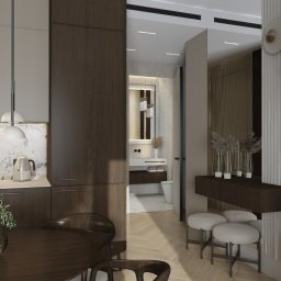 Architektura Wnętrz Patryk Bartkowski - Nowoczesne wnętrze: kuchnia z ciemnymi szafkami, marmurowy backsplash, okrągły stół z rośliną, widok na łazienkę i dekoracyjną ścianę z roślinami.