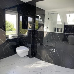 Brylant.BaU - Nowoczesna łazienka z czarnymi płytkami imitującymi marmur z białymi żyłami, białymi płytkami podłogowymi z podobnym wzorem, kabiną prysznicową ze szkła, podwieszaną toaletą i dużym lustrem...