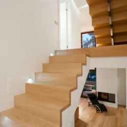 Nowoczesne drewniane schody z podświetleniem LED w minimalistycznym wnętrzu, widok na salon z kominkiem i leżanką.