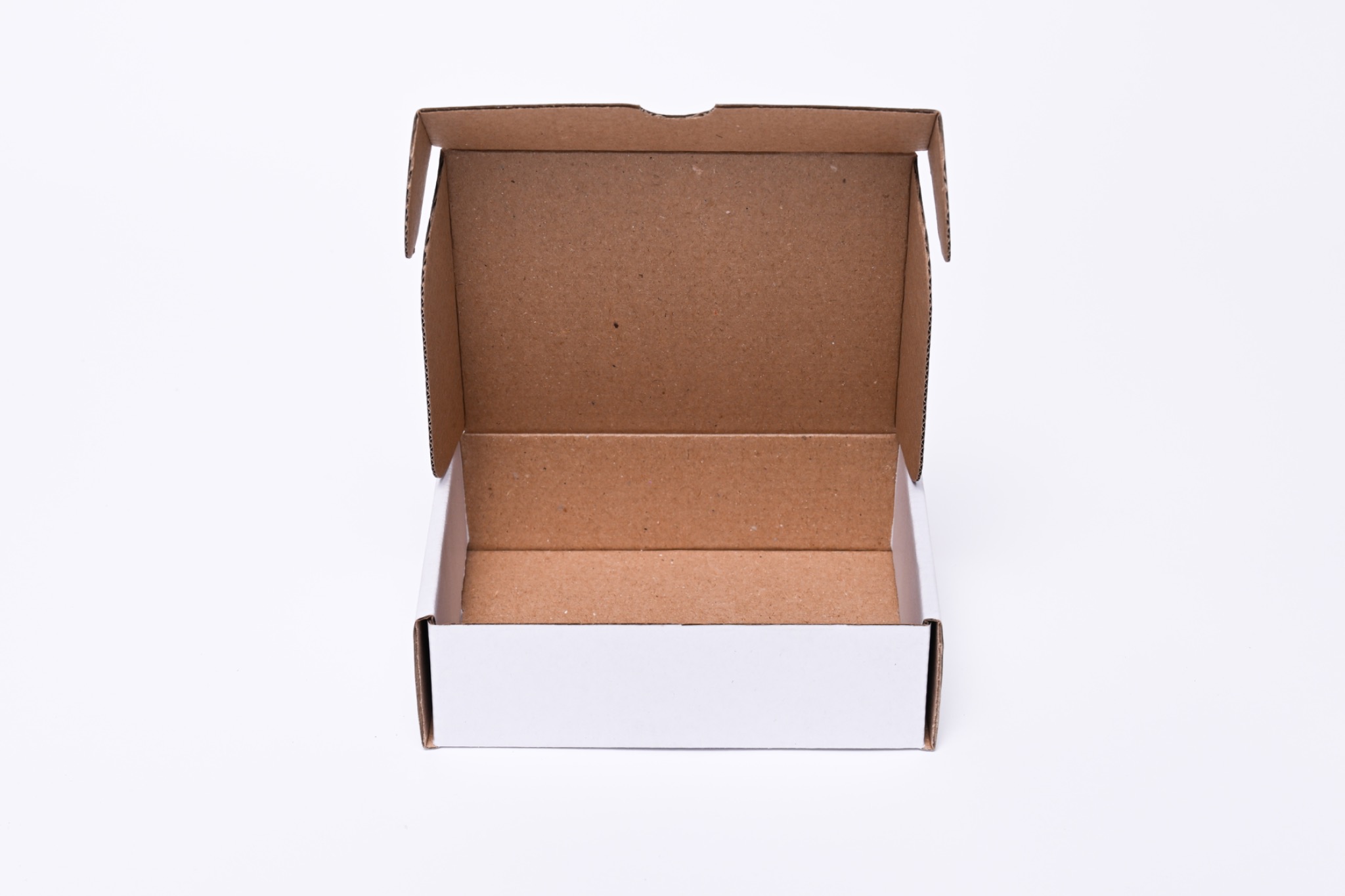 Otwarty, biały karton z brązowym wnętrzem, widoczny od przodu na białym tle.
