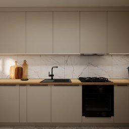 Jotem Studio - Wizualizacja nowoczesnej kuchni z beżowymi szafkami, drewnianym blatem, marmurowym backsplashiem i czarną armaturą, oświetlona listwą LED pod szafkami wiszącymi.