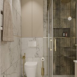 Jotem Studio - Nowoczesna łazienka z marmurowymi ścianami, kabiną prysznicową z deszczownicą, podwieszaną toaletą z bidetką i złotymi akcentami.