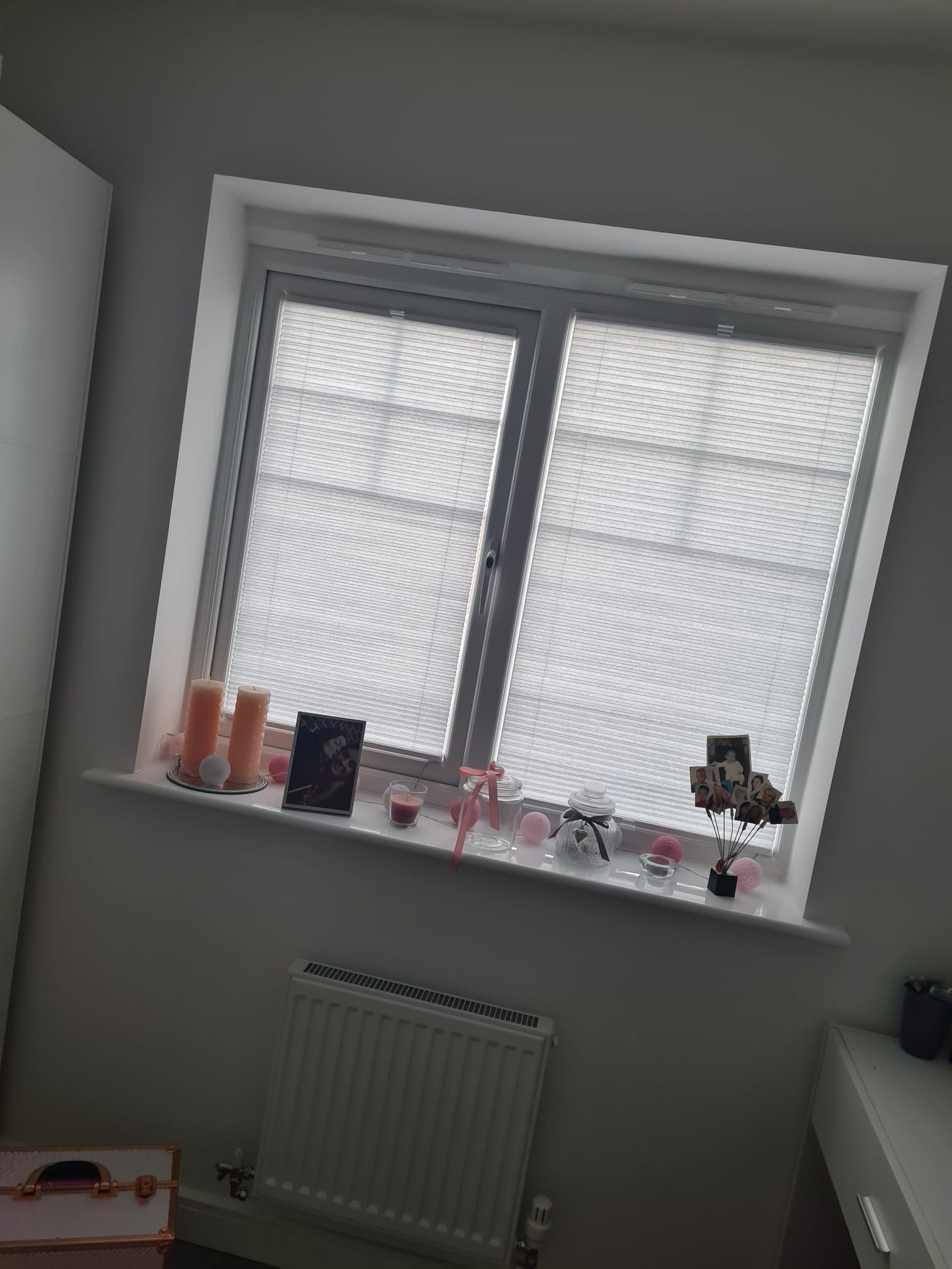 Okna strychowe z białymi plisami w Kielcach, ozdobione dekoracjami na parapecie, widok z wnętrza pokoju.