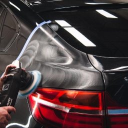 MYJNIA STARS CAR - Polerowanie lakieru czarnego samochodu za pomocą polerki Rupes. Widoczne hologramy na lakierze przed polerowaniem. Taśma maskująca zabezpiecza krawędzie.