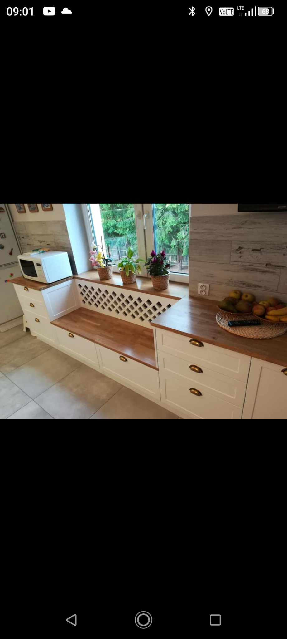 Kuchnia z frontami lakierowanymi, z lakierowaną kratką jako osłona grzejnika i blat drewniany lakierowany.