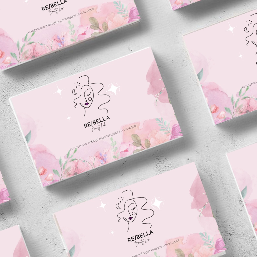 Stos wizytówek salonu kosmetycznego RE/BELLA Beauty Lab z motywem kwiatowym i minimalistycznym logo przedstawiającym kobiecą twarz.