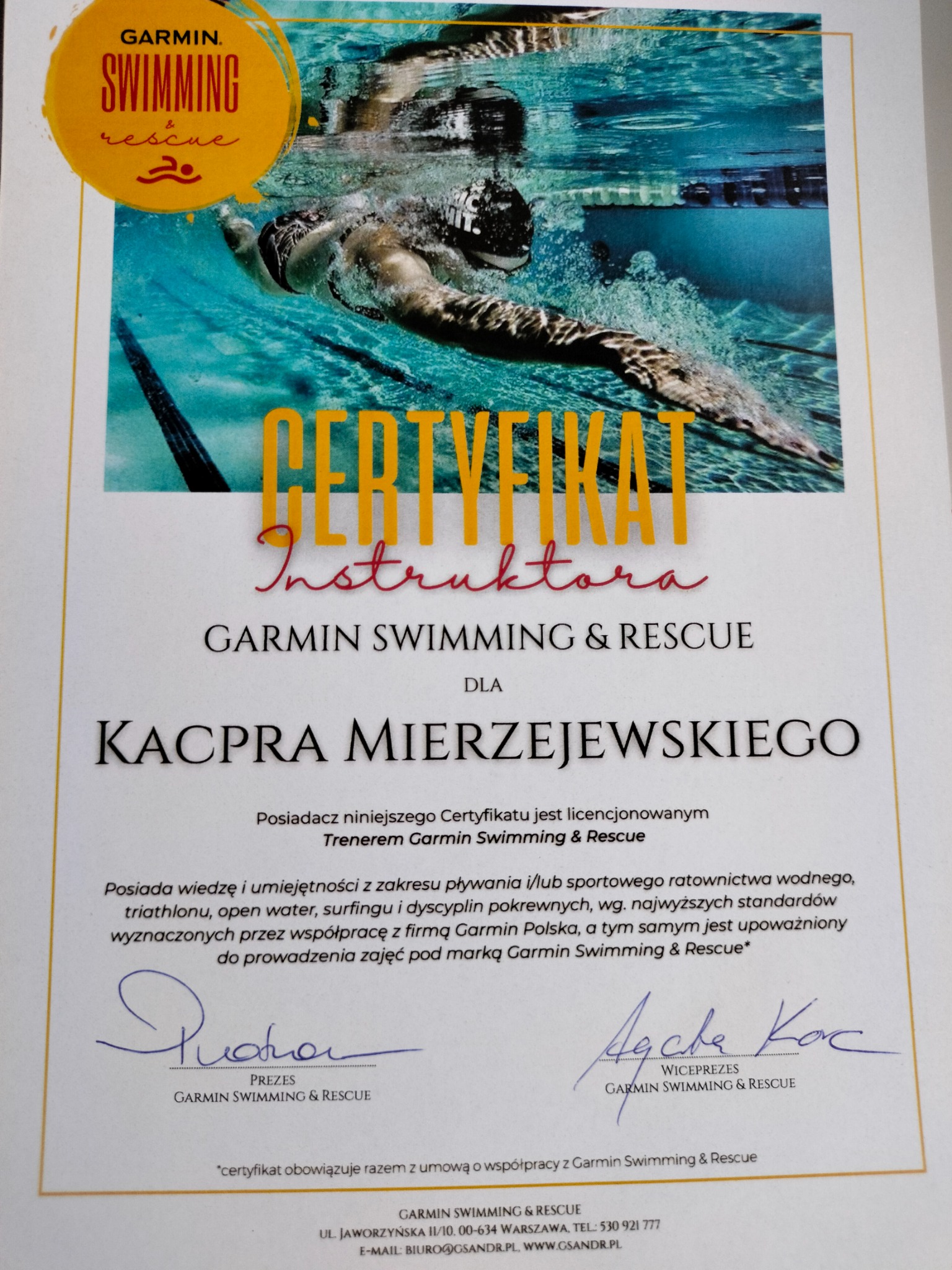 Certyfikat instruktora Garmin Swimming & Rescue dla Kacpra Mierzejewskiego, z wizerunkiem pływaka pod wodą w tle.
