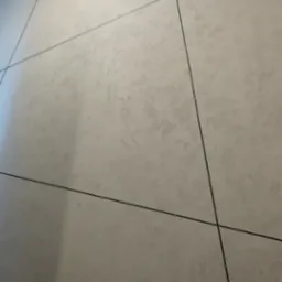 Fragment ściany wykończonej płytami kartonowo-gipsowymi z widocznymi czarnymi fugami, ujęcie pod kątem.