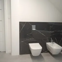 Nowoczesna łazienka na poddaszu z białą ceramiką sanitarną: wisząca toaleta i bidet na tle czarnych płytek imitujących marmur z białymi żyłami, białe ściany i drzwi z poziomymi frezami, szara...