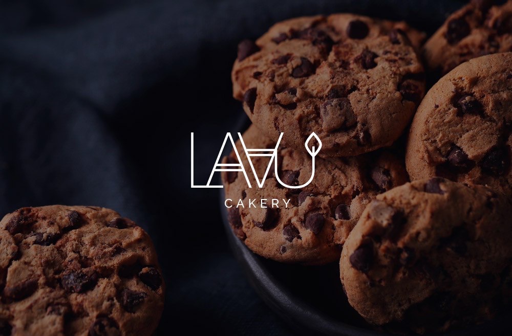 Stos ciasteczek z kawałkami czekolady na ciemnym talerzu, z minimalistycznym białym logo 'LAVU Cakery' na pierwszym planie.