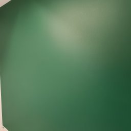 Pro Standard Bartłomiej Miczołek - Świeżo pomalowana na zielono ściana z widocznymi otworami na gniazdka elektryczne w dolnej części, sufit w kolorze białym.