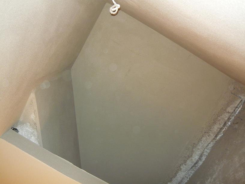 Wnętrze otynkowanego poddasza z widocznym fragmentem sznurka mocującego, świeżo po nałożeniu tynku maszynowego.
