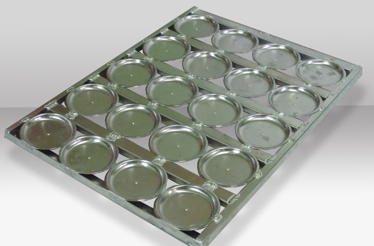 Metalowa forma z okrągłymi wgłębieniami, prawdopodobnie do wypieku babeczek lub muffinek, spawana konstrukcja nośna.