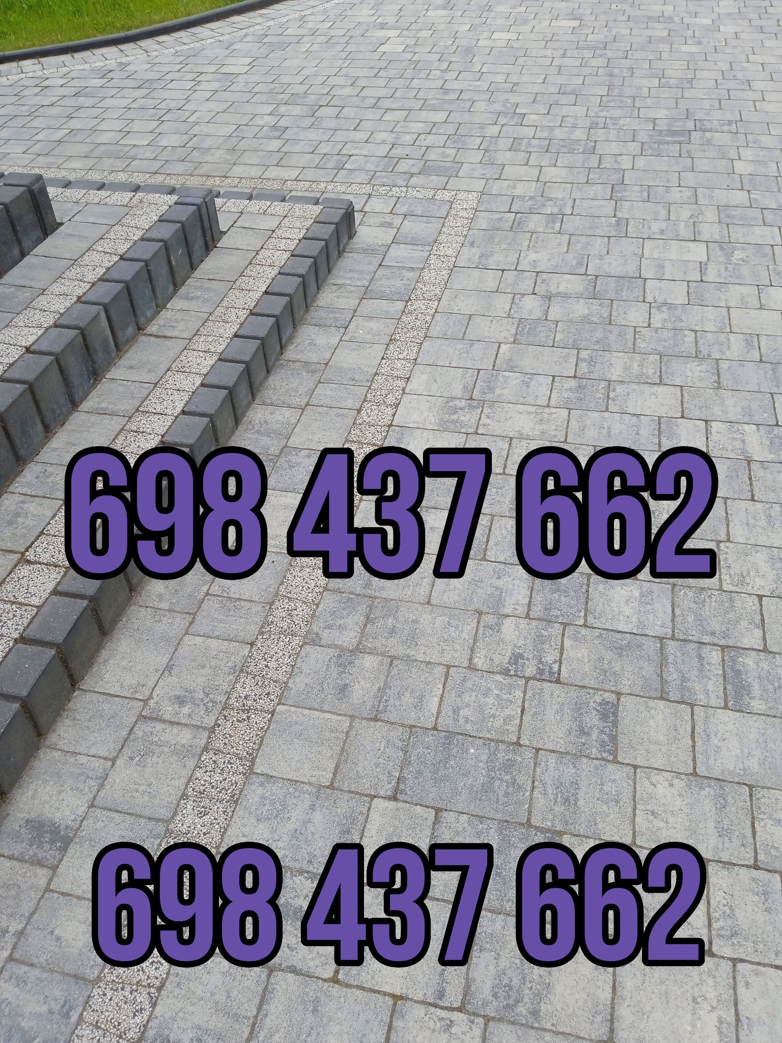 Ułożona kostka brukowa w odcieniach szarości z ozdobnym pasem z drobnych kamyczków oraz numerem telefonu naniesionym na zdjęcie.