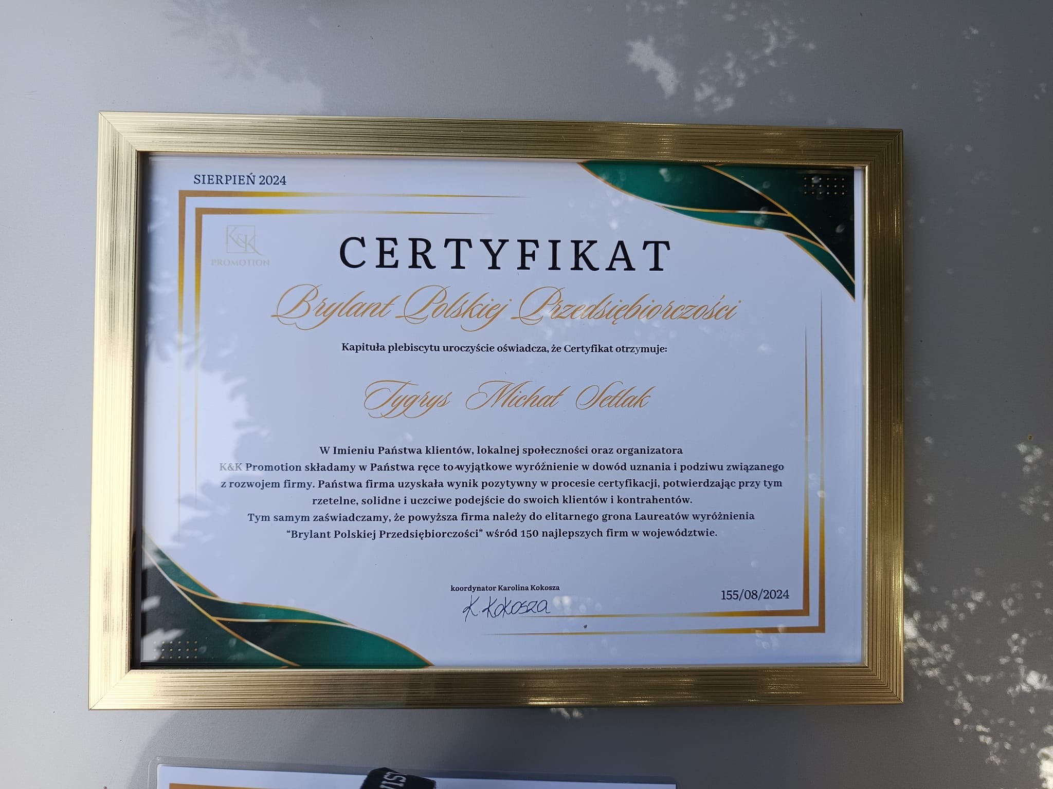 Certyfikat Brylant Polskiej Przedsiębiorczości w złotej ramce, przyznany firmie Tygrys Michał Sellak, koordynowany przez Karolinę Kokoszę, z datą sierpień 2024.
